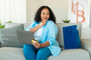 African Lady Holding Credit Card Using Laptop Shopping At Home