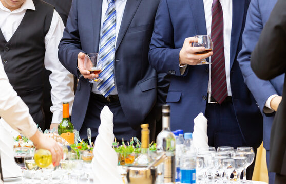 Businessmen at the banquet drink alcoholic beverages and have a snack. Buffet. Catering. Restaurant business.