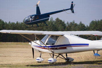 RECREATIONAL AND DISPOSABLE AVIATION - A small plane and a helicopter at a field airport