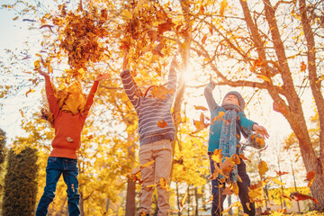 Children playing together in colourful natural park in autumnal day