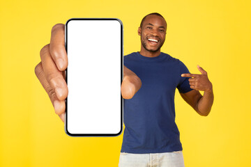African American Man Showing Big Smartphone Blank Screen, Yellow Background
