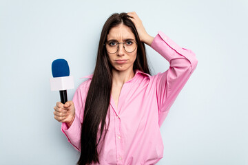 Young caucasian tv presenter woman isolated on blue background being shocked, she has remembered important meeting.