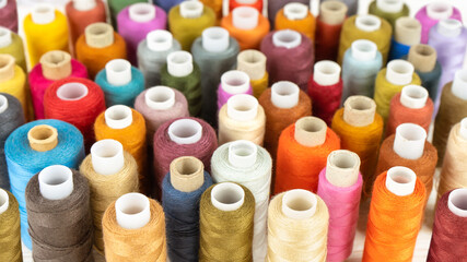 Sewing thread spools multicolored background, scattering of various colors sewing threads, colored...