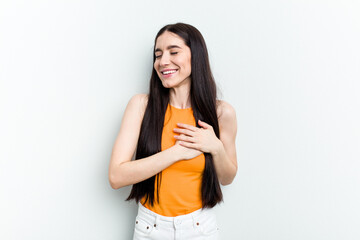Fototapeta na wymiar Young caucasian woman isolated on white background laughing keeping hands on heart, concept of happiness.
