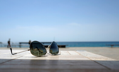 Fototapeta na wymiar Sunglasses on a table near the coast