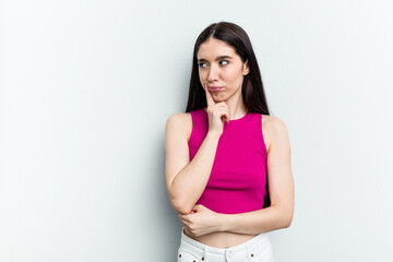 Young caucasian woman isolated on white background looking sideways with doubtful and skeptical expression.