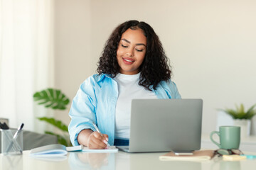 African American Lady Using Laptop Taking Notes Working In Office
