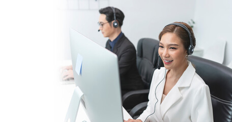 Fototapeta na wymiar Asian call center agent team, customer service support wearing headset or headphone talking with customer in modern office.