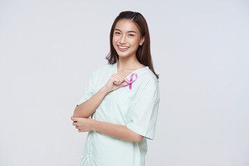 Happy asian woman patient showing pink badge ribbon chest to support breast cancer cause. breast...