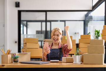 Happy young asian woman entrepreneur, Smile for sales success after checking order from online...