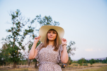 A young woman in a hat in a clearing. A walk in the park or forest. Outdoor recreation. The atmosphere of freedom and tranquility.