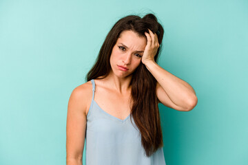 Young caucasian woman isolated on blue background tired and very sleepy keeping hand on head.