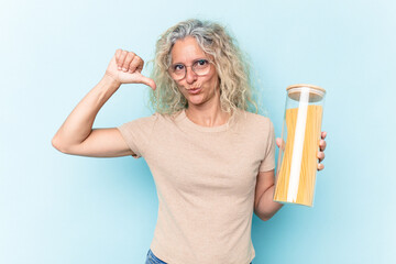 Middle age caucasian woman holding a spaghettis jar isolated on blue background feels proud and self confident, example to follow.