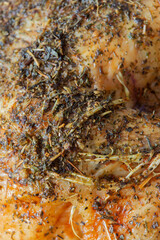 Close-up of a roast chicken seasoned with mixed herbs. Herbs include sage, thyme, marjoram, oregano, parsley and rosemary