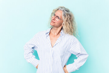 Middle age caucasian woman isolated on blue background dreaming of achieving goals and purposes