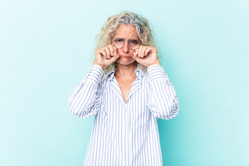 Middle age caucasian woman isolated on blue background whining and crying disconsolately.