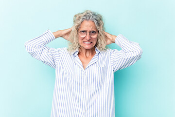 Middle age caucasian woman isolated on blue background screaming with rage.