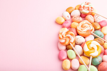 Fototapeta na wymiar Various caramel candies on pink background. copy space, side view