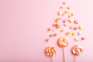 Various caramel candies on pink background. copy space, top view