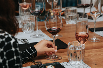 Red wine by the glass at a tasting of white, rosé and red wines that celebrates friendship and joy at the highest level with your best friends on a weekend evening full of people from social media.