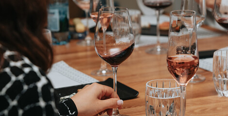 Red wine by the glass at a tasting of white, rosé and red wines that celebrates friendship and joy at the highest level with your best friends on a weekend evening full of people from social media.