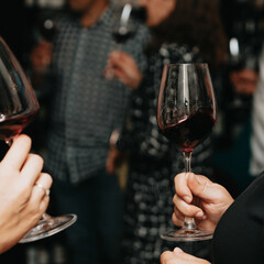 Red wine by the glass at a tasting of white, rosé and red wines that celebrates friendship and joy at the highest level with your best friends on a weekend evening full of people from social media.