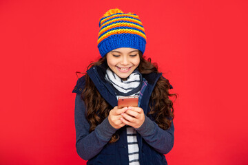 portrait of child blogging with phone. express positive emotion. greeting with winter holidays.