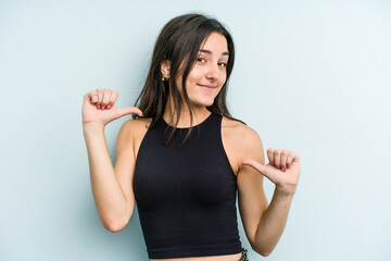 Young caucasian woman isolated on blue background feels proud and self confident, example to follow.