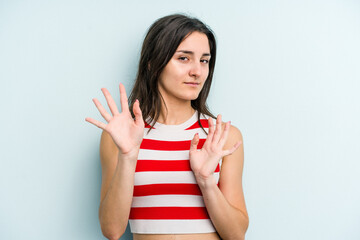 Young caucasian woman isolated on blue background rejecting someone showing a gesture of disgust.