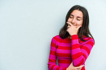 Young caucasian woman isolated on blue background laughing happy, carefree, natural emotion.