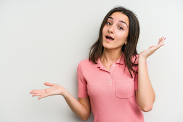 Young caucasian woman isolated on white background holds copy space on a palm, keep hand over...