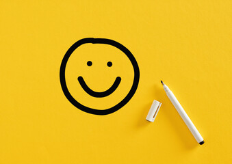 Smiling happy face sketch hand drawn with a felt tip marker pen on yellow background. Client...