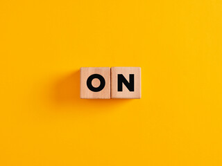The word off on wooden cubes on yellow background. To end or to close concept. Power on or...