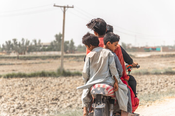 for friends are ridding a bike in a village and enjoying 