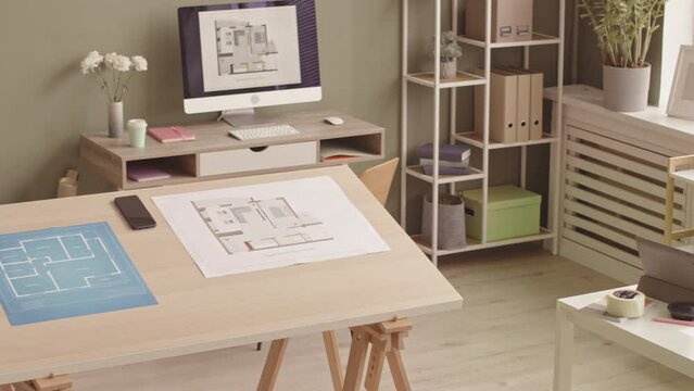 No people PAN slowmo of modern architectural office interior with blueprints and building plans on table and computer desktop