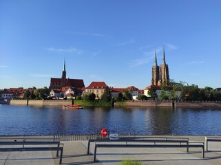 Panorama of Ostrów Tumski in Wrocław, Poland. View from the other side of the Odra River. Sunny evening in August. - obrazy, fototapety, plakaty