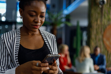 Happy businesswoman using smartphone in office