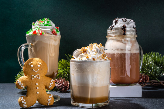Autumn winter coffee latte set, Autumn winter coffee drink assortment with various topping - gingerbread caramel, mocha chocolate, candy cane peppermint latte in different cups, over dark background