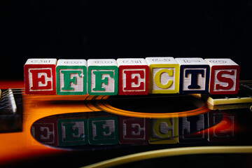 Word or phrase Effects made with letter cubes, standing on guitar.