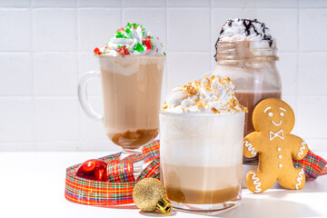 Autumn winter coffee latte set, Autumn winter coffee drink assortment with various topping - gingerbread caramel, mocha chocolate, candy cane peppermint latte in different cups, on white background