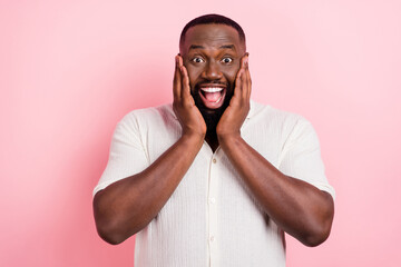 Portrait of astonished person arms touch cheeks incredible information isolated on pink color...