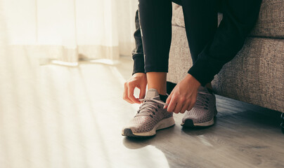 High angle view of woman tying shoelace on floor at home