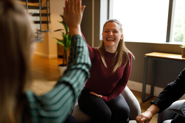 Businesswoman giving a high five to a colleague in meeting
