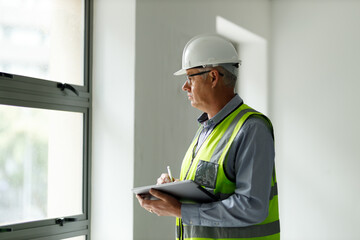 Professional senior engineer builder old man work looking at contract detail document paper