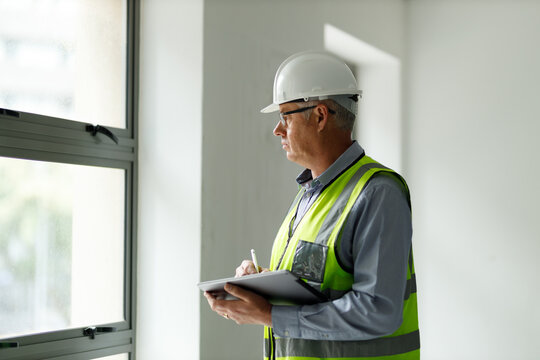 Professional senior engineer builder old man work looking at contract detail document paper