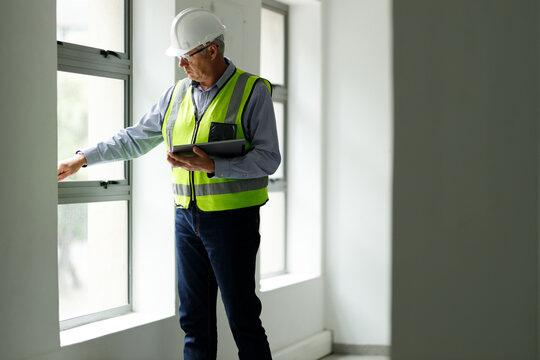 Professional senior engineer builder old man work looking at contract detail document paper