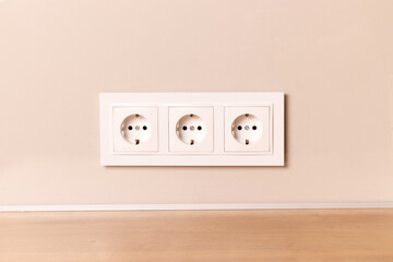 Group of white european electrical outlets on modern neutral beige wall