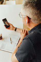 Mature businessman talking on video call in office