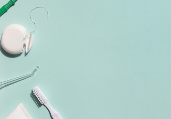 Dental care concept frame with toothbrush, irrigator, tooth floss and toothpaste on the blue...