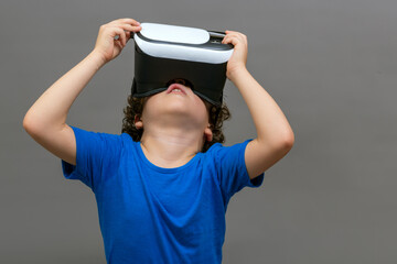 photo of curly-haired caucasian boy wearing virtual reality glasses